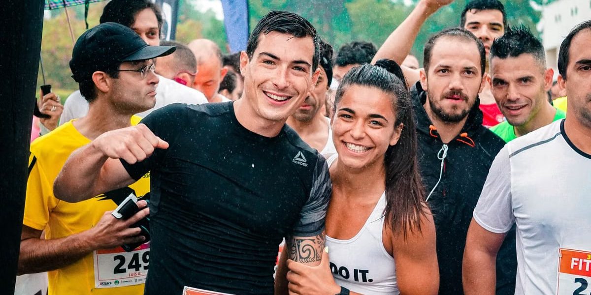 Group of runners smiling in the rain during a marathon race event.