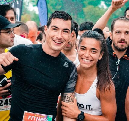 Group of runners smiling in the rain during a marathon race event.